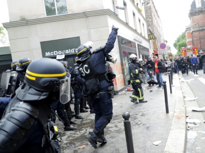 Un CRS lance une grenade lacrymogène contre des manifestants en marge du défilé syndical du 1er mai 2018 à Paris - Thomas SAMSON [AFP]