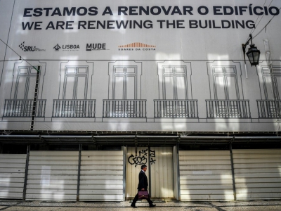 Un homme passe devant un immeuble en rénovation de la place du Rossio, à Lisbonne, le 19 avril 2018 - PATRICIA DE MELO MOREIRA [AFP]