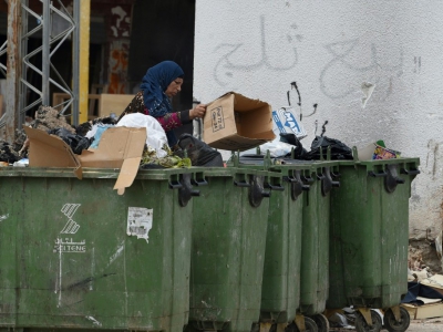 Une Tunisienne trient des déchets dans un quartier populaire en banlieue de la capitale Tunis, le 30 avril 2018 - FETHI BELAID [AFP]
