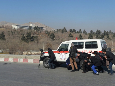 Sur ce cliché pris en janvier 2018 par le photographe de l'AFP Shah Marai, tué lundi dans un attentat à Kaboul, des journalistes s'abritent derrière une ambulance durant des combats dans la capitale afghane - SHAH MARAI [AFP/Archives]