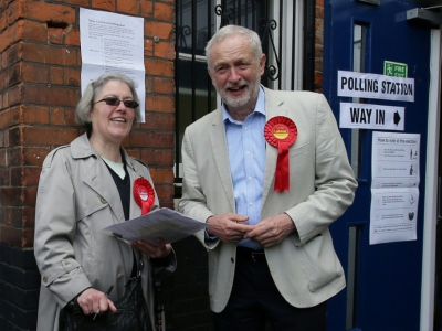 Le chef de l'opposition travailliste  Jeremy Corbyn parle avec une militante devant un bureau de vote le 3 mai 2018 à Londres. - Daniel LEAL-OLIVAS [AFP]