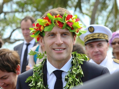 Le président Emmanuel Macron, une couronne de fleurs sur la tête, lors d'une cérémonie de bienvenue à Ouvéa, le 5 mai 2018 en Nouvelle-Calédonie - LUDOVIC MARIN [AFP]