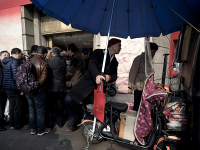Chaque week-end, ce sont désormais plusieurs dizaines de boursicoteurs qui se retrouvent au même coin de rue à Shanghai - Johannes EISELE [AFP]