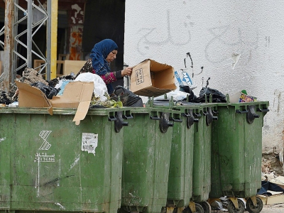 Une Tunisienne trient des déchets dans un quartier populaire en banlieue de la capitale Tunis, le 30 avril 2018 - FETHI BELAID [AFP]