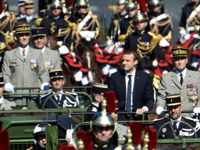 Le président Emmanuel Macron (c) et le général Pierre de Villiers,chef d'état-major des forces armées, remonte les Champs-Elysées à bord d'un véhicule militaire, lors du défilé du 14 juillet 2017 à Paris - ALAIN JOCARD [AFP/Archives]