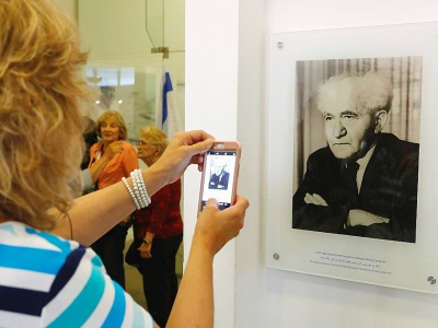 Une touriste photographe un portrait de David Ben Gourion, le premier chef d'un gouvernement israélien,  le 3 mai 2018 à Tel-Aviv dans le bâtiment devenu musée où ce dernier avait déclaré la création de l'Etat d'Israël - JACK GUEZ [AFP/Archives]