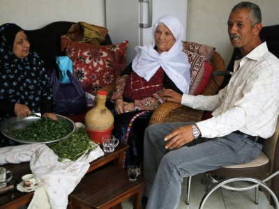 Khadija Sharkawi (C) est assise avec sa famille dans sa maison située dans le camps de réfugiés d'Al-Amari, en Cisjordanie occupée - ABBAS MOMANI [AFP]