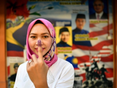 Une habitante de Kuala Lumpur montre l'encre sur son doigt après son vote le 9 mai 2018 - Manan VATSYAYANA [AFP]