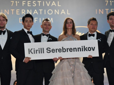 L'équipe du film "Leto", en lice pour la Palme d'or, brandit une pancarte où est inscrite le nom du réalisateur russe Kirill Serebrennikov, sur les marches de Cannes, le 09 mai 2018 - Alberto PIZZOLI [AFP]