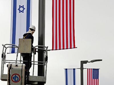 Un homme installe le 7 mai 2018 les drapeaux israélien et américain devant le consulat américain à Jérusalem où les Etats-Unis vont déménager leur ambassade - THOMAS COEX [AFP]