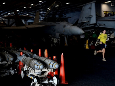 Un membre de l'équipage du porte-avion USS HArry S. Truman fait un jogging devant des chasseurs Super Hornet F-18, le 8 mai 2018 - Aris MESSINIS [AFP]