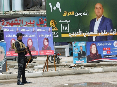 Un policier irakien à un check-point devant des affiches électorales, le 11 mai 2018 à Mossoul, en Irak - AHMAD AL-RUBAYE [AFP]
