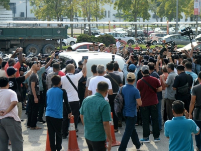Une foule entoure un véhicule blanc se rendant à l'aéroport Sultan Abdul Aziz Shah à Subang, près de Kuala Lumpur, le 12 mai 2018, pour vérifier si l'ex-Premier ministre Najib Razak et son épouse Rosmah Mansor se trouvent à l'intérieur - ROSLAN RAHMAN [AFP]