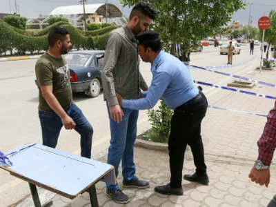 Un Irakien est fouillé par un policier avant de se rendre dans un bureau de vote de la ville de Kerbala (centre) le 12 mai 2018 lors des élections législatives - Mohammed SAWAF [AFP]
