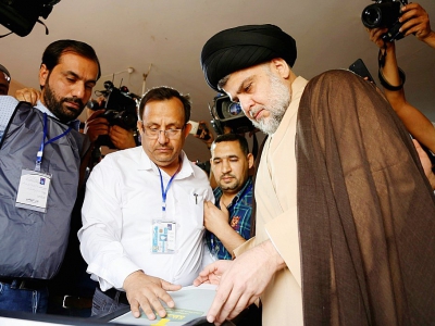 Le leader chiite irakien Moqtada al-Sadr (R) vote lors des élections législatives dans la ville de Najaf, dans le centre de l'Irak, le 12 mai 2018 - Haidar HAMDANI [AFP]