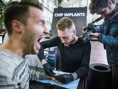 Un homme réagit alors qu'un autre insère un implant sous sa peau, à Stockholm, le 18 janvier 2018 - Jonathan NACKSTRAND [AFP]