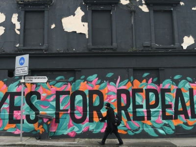 Un homme passe devant un graffiti appelant à voter "Oui", au référendum sur l'avortement en Irlande, à Dun Laoghaire, le 10 mai 2018 - Artur Widak [AFP/Archives]