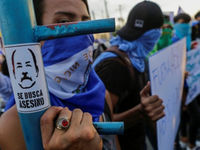 Un étudiant brandit une pancarte sur laquelle est dessiné le président du Nicaragua Daniel Ortega avec écrit, au-dessous "assassin recherché", à Managua le 15 mai 2018 - DIANA ULLOA [AFP]