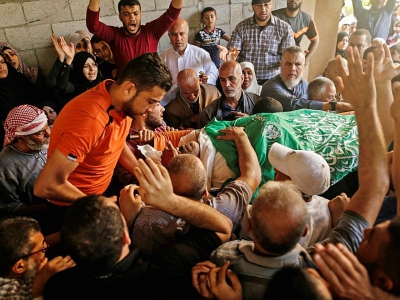 Des Palestiniens portent le corps de Nasser Ghorab, tué mardi lors de heurts avec les forces israéliennes près de la frontière entre la bande de Gaza et Israël, le 16 mai 2018 lors de ses funérailles dans le camp de réfugiés de Nousseirat - MAHMUD HAMS [AFP]