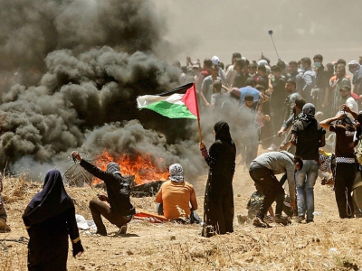 Une femme palestinienne tenant un drapeau palestinien, à la frontière entre Gaza et Israel, le 14 mai 2018 - MAHMUD HAMS [AFP/Archives]