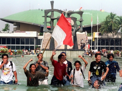 Des étudiants indonésiens fêtent le départ de Suharto devant le Parlement à Jakarta, le 21 mai 1998 - KEMAL JUFRI [AFP/Archives]