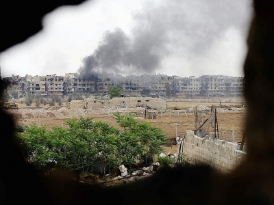Un nuage de fumée s'élève du camp de réfugiés palestiniens de Yarmouk dans le sud de la capitale syrienne, après des bombardements du régime contre des positions du groupe Etat islamique (EI), le 29 avril 2018 - LOUAI BESHARA [AFP/Archives]