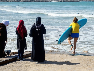 Une surfeuse en tenue de bain entre dans l'eau sur une plage de Rabat, le 1er avril 2018 - FADEL SENNA [AFP]