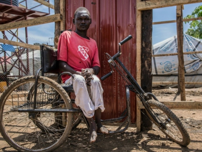 John Alan, victime de la polio, utilise un tricycle pour se déplacer dans le camp de Mahad, à Juba, au Soudan du Sud, le 17 avril 2018 - Stefanie Glinski [AFP]