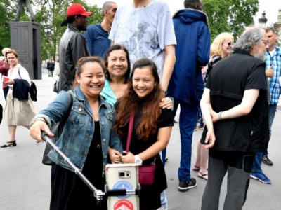Des touristes font des selfies avec Brahim Takioullah, 2m46, sur les Champs-Elysées à paris le 1er juin 2018 - GERARD JULIEN [AFP]