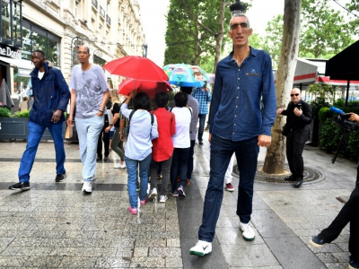 Abdramane Dembele, 2m35, Brahim Takioullah, 2m46, et Arshavir Grigoryan, 2m33, marchent sur les Champs-Elysées à Paris le 1er juin 2018 - GERARD JULIEN [AFP]