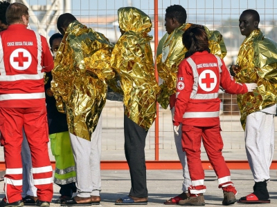 Des membres de la Croix-Rouge italienne prennent en charge des migrants débarqués du bateau de l'ONG allemande Sea Watch3, le 8 novembre 2017 à Pozzallo, en Sicile - Giovanni Isolino [AFP/Archives]