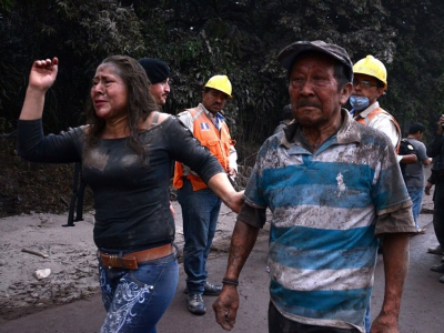 Des personnes fuient le village d'  El Rodeo, à 35 km au sud de la ville de Guatemala, après l'erruption du volcan Fuego le 3 juin 2018 - NOE PEREZ [AFP]