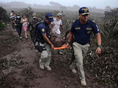 Des policiers évacuent un blessé lors de l'érruption du volcan Fuego, dans le village d'El Rodeo village, à 35 km au sud de la ville Guatemala le 3 juin 2018 - NOE PEREZ [AFP]
