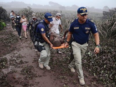 Des policiers évacuent un blessé lors de l'érruption du volcan Fuego, dans le village d'El Rodeo village, à 35 km au sud de la ville Guatemala le 3 juin 2018 - NOE PEREZ [AFP]