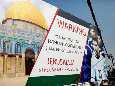 Une affiche dans une rue d'Hébron, en Cisjordanie occupée, le 5 juin 2018, dénonçant le match à venir Israël-Argentine pour la préparation au Mondial-2018 - HAZEM BADER [AFP]