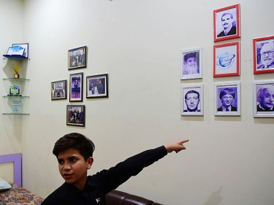 Hammad Safi, 11 ans, "coach en motivation", montre des photos dans sa chambre de l'University of spoken english, le 3 avril 2016 à Peshawar, au Pakistan - ABDUL MAJEED [AFP]