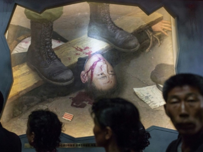 Un groupe de visiteurs passe devant un tableau représentant des soldats américains torturant un Nord-Coréen, le 24 juillet 2017 au Musée des atrocités de guerre américaines à Sinchon, en Corée du Nord - Ed JONES [AFP]