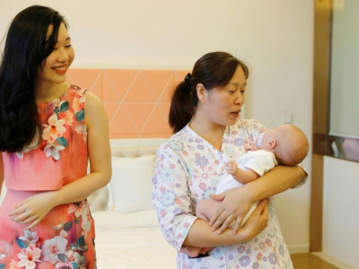 Xu Jingfang (g), la maman du petit Kirk bercé par une nounou, au Centre post-natal international du lac Malaren,  le 17 mai 2018 à Shanghai - - [AFP]