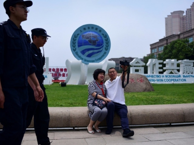 Un couple prend un selfie devant une installation de l'Organisation de coopération de Shanghai, le 8 juin 2018 à Qingdao, en Chine - WANG ZHAO [AFP]
