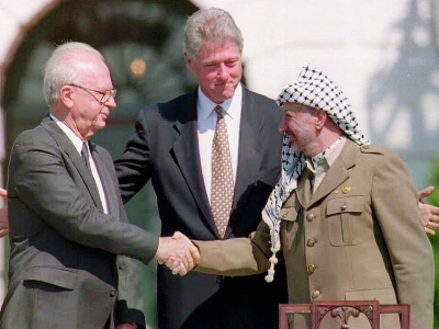 Le Premier ministre israélien Yitzhak Rabin et le leader de l'Organisation de libération de la Palestine (OLP) Yasser Arafat se serrent la main en présence du président américain Bill Clinton (c), le 13 septembre 1993 à Washington - FILES/J. David AKE [AFP/Archives]