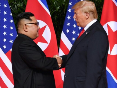 Le leader nord-coréen Kim Jong Un (g) et le président américain Donald Trump se serrent la main, le 12 juin 2018 à l'hôtel Capella sur l'île de Sentosa, à Singapour - SAUL LOEB [AFP]
