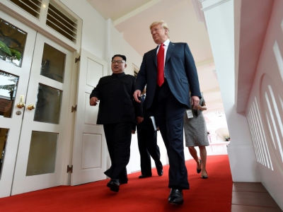 Le leader nord-coréen Kim Jong Un (g) et le président américain Donald Trump marchent ensemble dans un couloir de l'hôtel Capella, sur l'île de Sentosa, le 12 juin 2018 à Singapour - SAUL LOEB [AFP]