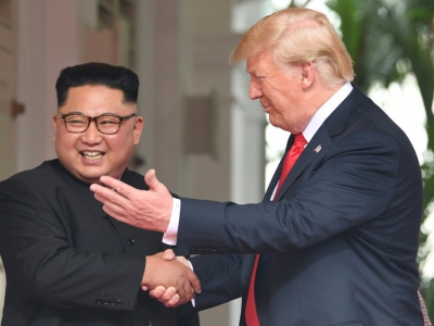Le leader nord-coréen Kim Jong Un (g) et le président américain Donald Trump se serrent à la main, le 12 juin 2018 à l'hôtel Capella, à Singapour - SAUL LOEB [AFP]