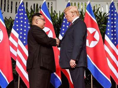 Le leader nord-coréen Kim Jong Un (g) serre la main au président américain Donald Trump (d) avant le début du sommet historique à l'hôtel Capella, le 12 juin 2018 à Singapour - SAUL LOEB [AFP]