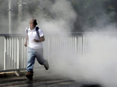 Un homme fuit les fumées de pneus en feu à Sebaco, à une centaine de km de Managua, le 11 juin 2018 - Inti Ocon [AFP]
