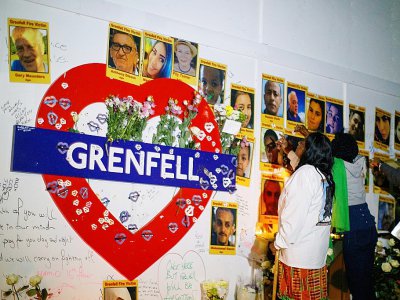 Des personnes se recueillent devant les photos des victimes de l'incendie de la Tour Grenfell, le 13 juin 2018 - Tolga Akmen [AFP]