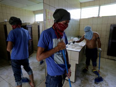 Des étudiants nettoient les toilettes de l'Université de Managua où ils sont retranchés, au Nicaragua, le 12 juin 2018 - INTI OCON [AFP]