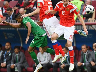 L'attaquant saoudien Salem Al-Dawsari (g) à la lutte avec les Russes Mario Fernandes (c) et Yuri Gazinskiy lors du match d'ouverture du Mondial, le 14 juin 2018 à Moscou - Kirill KUDRYAVTSEV [AFP]