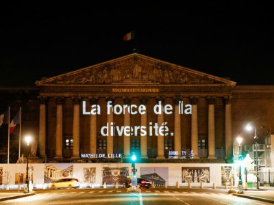 Une des "raisons" d'accueillir les migrants projetées sur la façade de l'Assemblée nationale par Amnesty International France, à Paris le 19 juin 2018 - GEOFFROY VAN DER HASSELT [AFP]