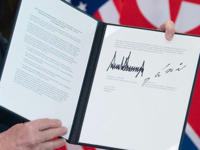 Le président américain Donald Trump brandit un document signé par le leadeur nord-coréen Kim Jong Un et lui, le 12 juin 2018, à Singapour - SAUL LOEB [AFP/Archives]